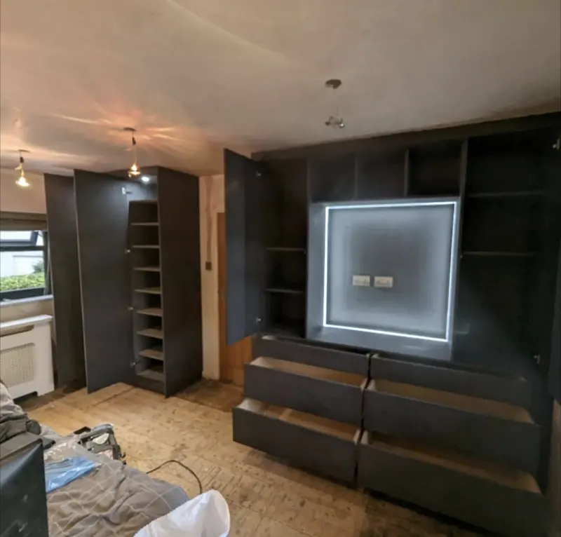 Dark media unit with the cupboards and drawers open, showing the storage inside