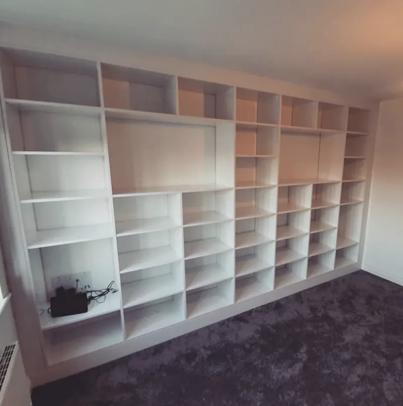 Full-wall white cube shelving unit with large and small compartments